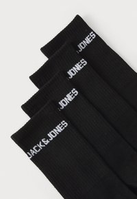 Schwarze Baumwollsocken mit gerippter Textur, versehen mit "JACK & JONES" in Weiß auf dem Bund, in einem Stapel angeordnet.