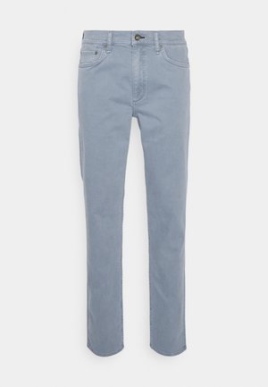 Jeans in denim azzurro chiaro con taglio dritto, chiusura a bottone e design a cinque tasche. Presenta dettagli di cucitura sottili e una texture liscia.
