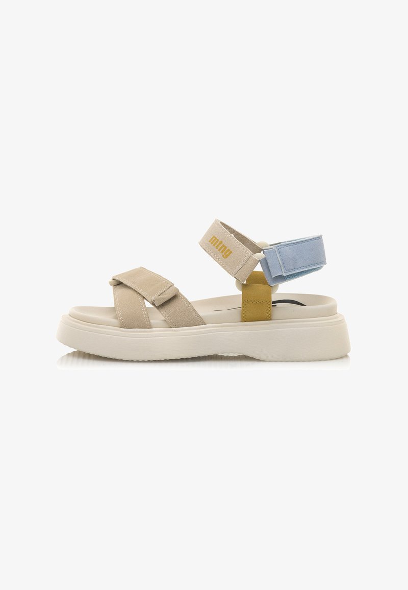 Sandalias de ante beige con correas ajustables. Presentan acentos en azul claro y amarillo, una suela blanca gruesa y un talón cerrado para mayor soporte.