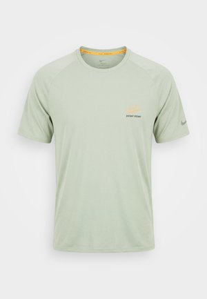 Lichtgroen Nike hardloop-T-shirt met korte mouwen, ronde hals, kleine "Distant Dreams"-print op de borst en Nike-swoosh op de linkermouw.