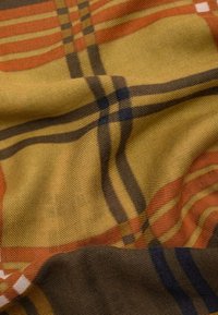 Tissu tissé avec un motif à carreaux en jaune, orange, marron et bleu marine. Surface texturée avec des fibres visibles et un drapé doux.