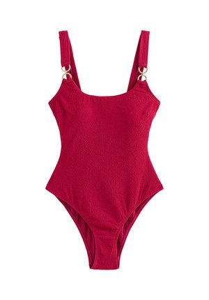 Rode one-piece badpak met textuur en brede schouderbanden met gouden ringdetails.
