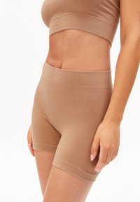 Shorts côtelés couleur sable avec une ceinture douce, dotés d'un design extensible et sans coutures ainsi que des accents minimalistes pour le confort et l'ajustement.