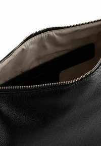 Zwarte leren tas met een gestructureerd oppervlak en een goudkleurige rits. De binnenkant is gevoerd met beige stof en heeft een vlak zakje.