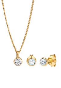 Collana in metallo dorato con pendente a cristallo rotondo, abbinata a tre orecchini a bottone rotondi coordinati in montatura dorata.