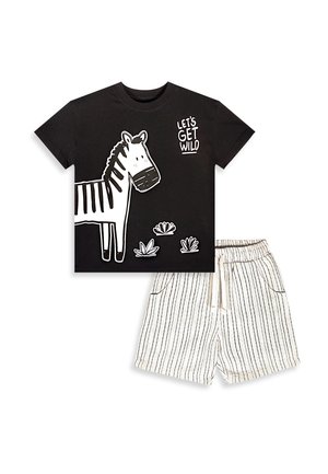 Chemise noire à manches courtes avec un zèbre blanc et le texte « LET'S GET WILD », combinée avec un short blanc à fines rayures verticales noires.