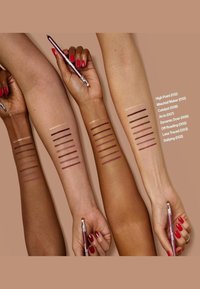 Trois bras aux teintes de peau variées présentent sept lignes horizontales de différentes nuances d'eyeliner. Un crayon de maquillage est tenu dans une main.