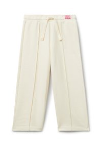 Krémové kalhoty s širokými nohavicemi, elastickým pasem a stahovací šňůrkou, se svislými švy a malou červenou nášivkou na pase.