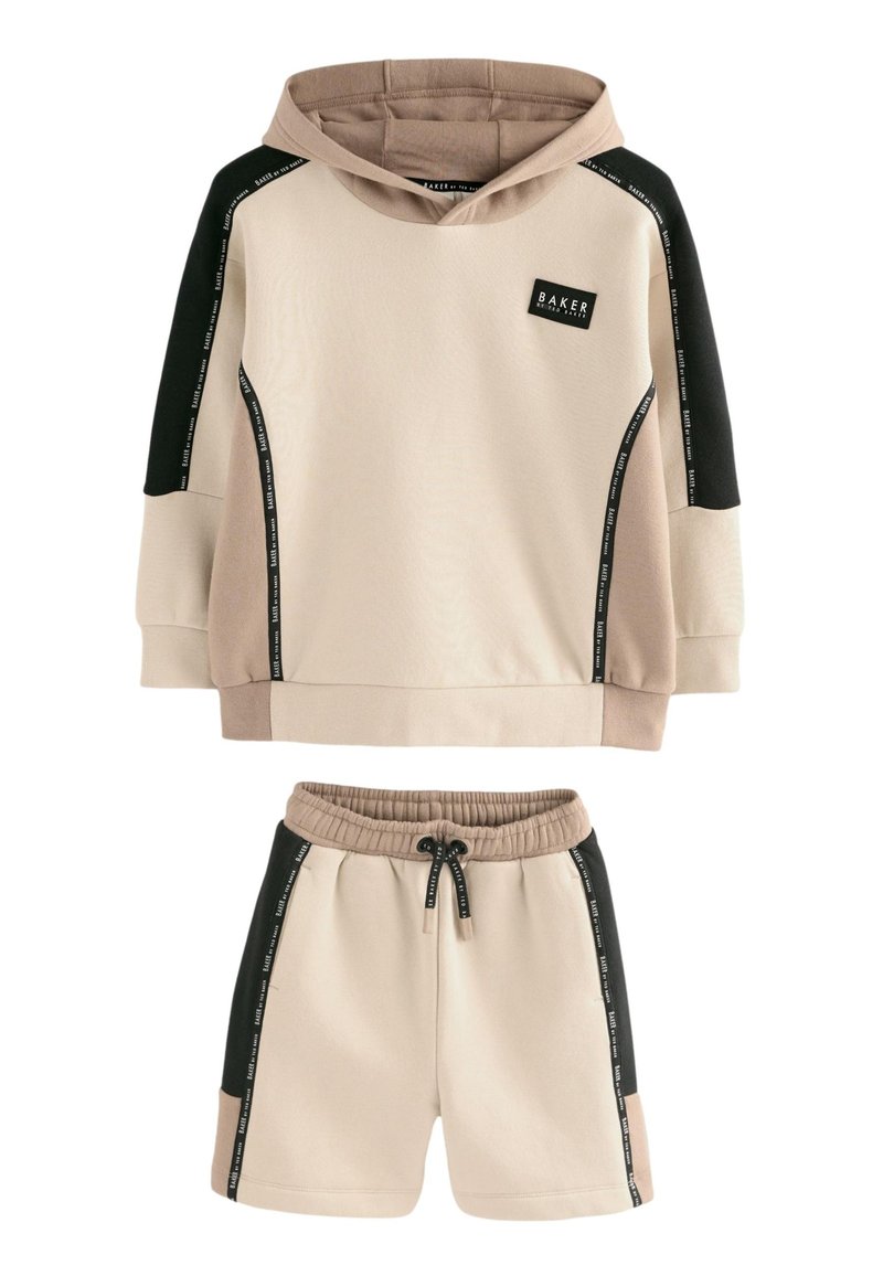Beige hættetrøje og matchende shorts med sorte sidepaneler, snøre i taljen og logo på brystet. Blødt, tekstureret stof.