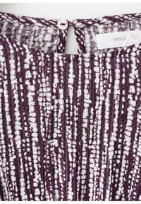 Violetti- ja valkokuviollinen kangas, jossa pystysuoria raitoja ja teksturoitu pinta. Kauluksessa pieni pyöreä nappikiinnitys.