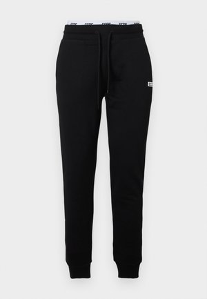 Zwarte sweatpants van glad materiaal, met een koord in de taille, taps toelopende pijpen en een klein logo op de linker voorkant.