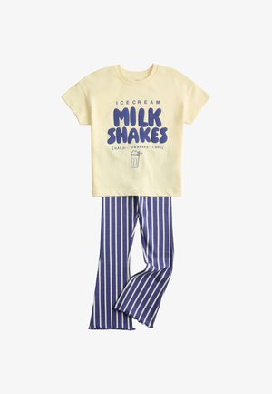 Gul t-shirt med korte ærmer med blå teksten "Milk Shakes" og illustration, kombineret med blå og hvide bukser med lodrette striber.
