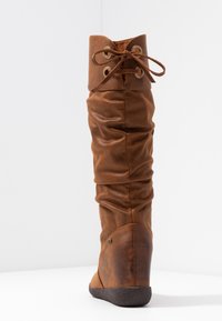 Botte haute marron en cuir avec un design décontracté, fermeture à lacets en haut et talon texturé. Caractéristiques : bout arrondi et semelle en caoutchouc.
