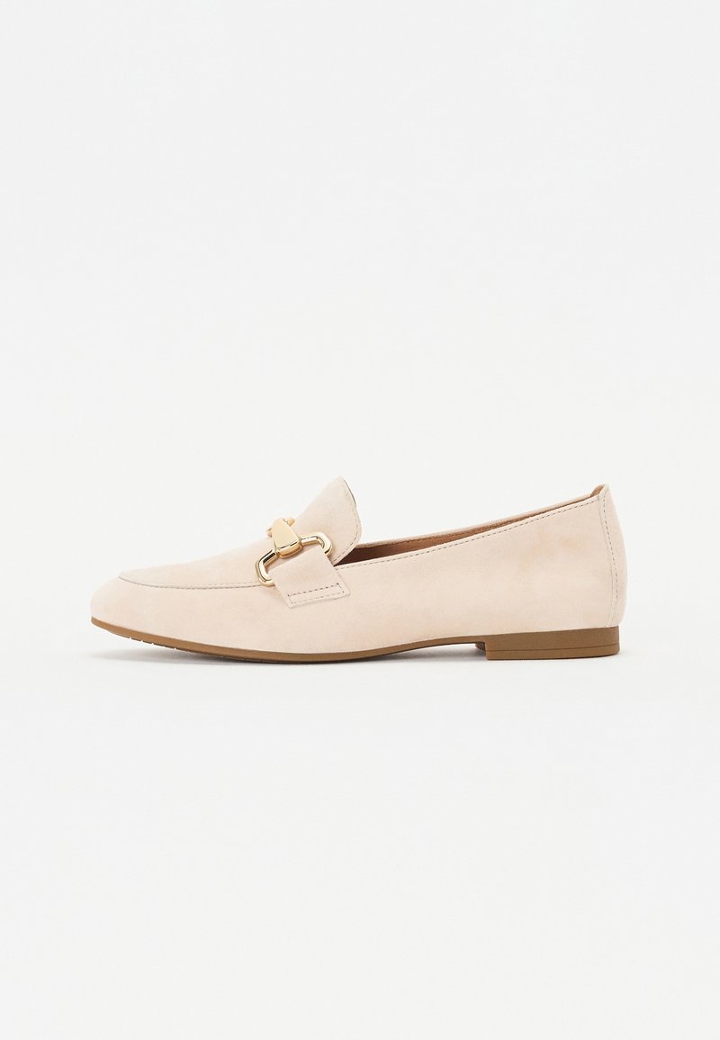 Mocassin beige en daim avec détail chaîne dorée, semelle plate marron et petit talon, présenté de profil sur fond blanc.