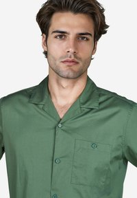 Korte mouwen, button-up shirt in donkergroen katoen met een zachte textuur, een kraag en een borstzak met een bijpassende knoop.