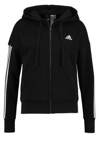 Sweat à capuche zippé noir en tissu doux avec des rayures blanches le long des manches et un petit logo Adidas sur la poitrine.