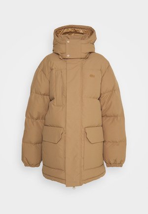 Puffer jacket in a light brown color, featuring a high collar, two front pockets, and elastic cuffs. Soft matte fabric with minimal detailing.