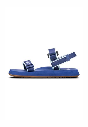 Blå sandal med justerbara remmar och ljusblå accenter, en texturerad gummisula och en platt fotsäng. Lämplig för avslappnad användning.