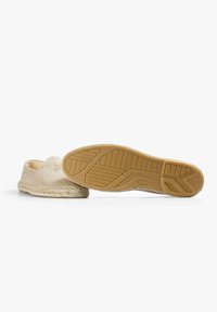Beige slip-on sko med et fiskebensmønster, jute-b trim og brun gummisål. Sålen har et struktureret design for bedre greb.