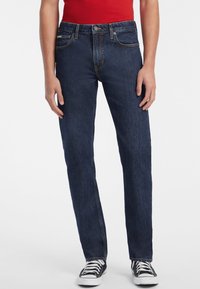 Jeans din denim de culoare bleu închis, cu croi drept, având buzunare frontale și un design clasic cu cinci buzunare, caracterizate prin cusături portocalii și un nasture metalic.