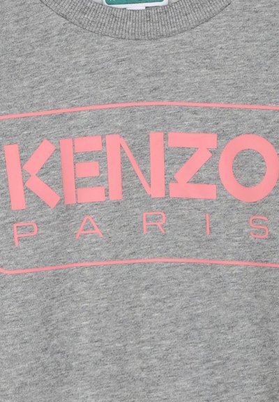 Sweatshirt gris avec un graphique audacieux en rose qui affiche "KENZO PARIS." Le tissu semble lisse avec un design à col rond.