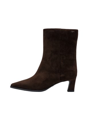 Dunkelbrauner Veloursleder-Stiefelette mit spitzer Kappe, niedrigem, zulaufendem Absatz und kleinem Metall-Logo nahe am oberen Rand an der Außenseite.