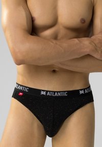 Czarne bokserki wykonane z bawełny z materiałem w plamki, z czarnym pasem w talii z białym logo "ATLANTIC" i małą czerwoną metką.