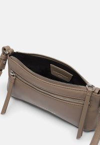 Piccola borsa a tracolla in pelle marrone con chiusura a cerniera, caratterizzata da una superficie testurizzata e una fodera interna nera.