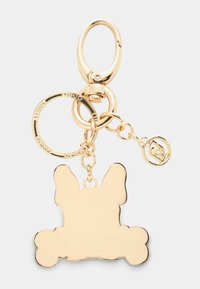 Zlato obarvan ključek s silhueto psa z izrazitimi ušesi in tačkami. Vključuje okroglo obrobo in majhno okroglo čarobnost. Gladka tekstura.