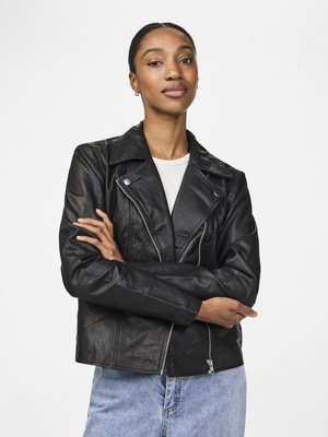 Black leather biker jacket with silver hardware, featuring a lapel collar and zipped pockets. Worn over a light-colored top and blue jeans.