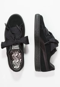 Baskets en daim noir Puma avec lacets ruban épais, détail bande latérale, semelle texturée, semelles intérieures et étiquettes de languette de marque.