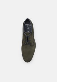 Scarpa stringata verde oliva scuro con tomaia in tessuto testurizzato, dettagli blu sui bordi e design a punta rotonda. Taglia 42.