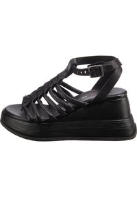 Černé kožené sandály na klínovém podpatku s několika křížovými pásky, polstrovanou platformou a nastavitelným páskem kolem kotníku s kovovou sponou.