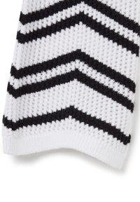 Tessuto a maglia bianco con una superficie testurizzata che presenta strisce a zigzag nere. I bordi sono rifiniti con un bordo a costine.