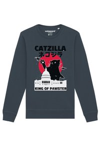 Donkerblauwe sweater met een grafisch ontwerp van een kat, tekst "CATZILLA" en "KING OF PAWSTER," met een witte Capitool en een rode achtergrond.