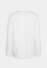 Långärmad vit t-shirt i bomull. Har rundad halsringning, ribbade mudd och en slätt material. Inga synliga mönster eller designelement.