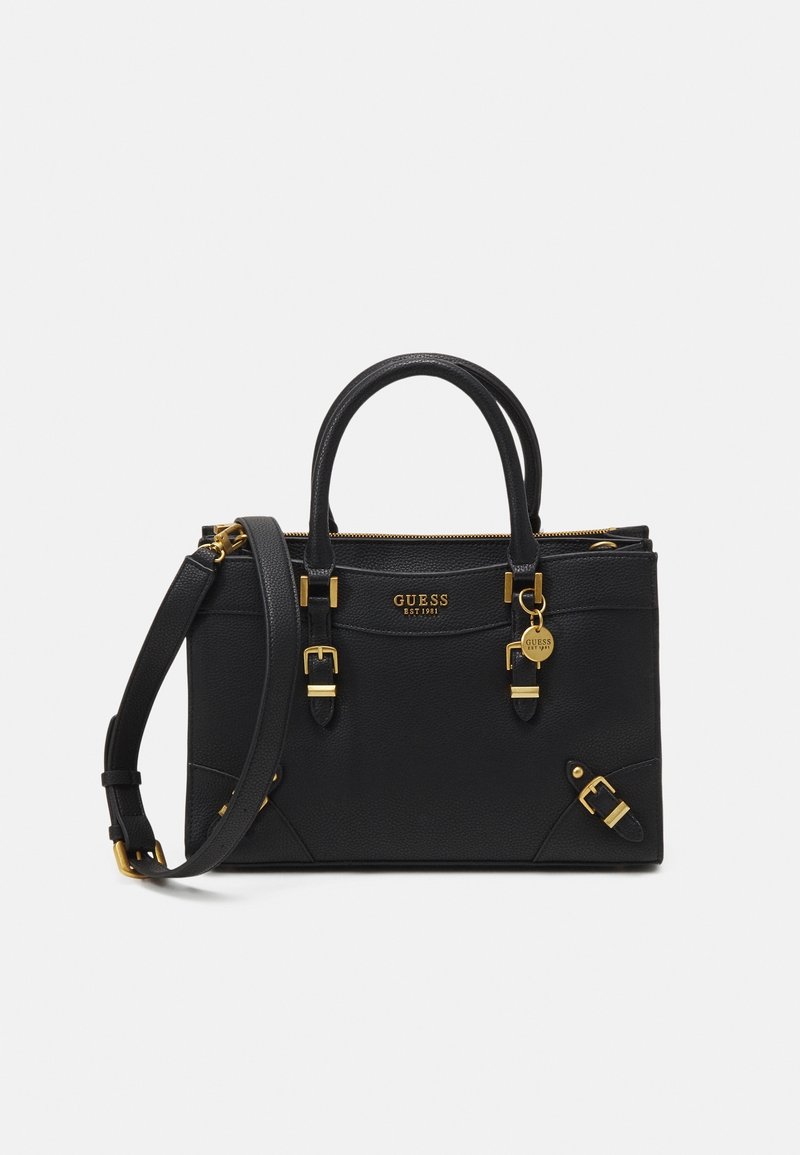 Sac à main Guess en cuir noir avec doubles poignées, bandoulière réglable, boucles dorées, fermeture éclair et breloque avec le logo de la marque.
