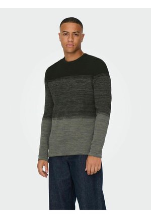 Langarm-Strickpullover in Schwarz-Grau-Gradient, mit Rundhalsausschnitt und strukturiertem Stoff, kombiniert mit dunkelblauen Jeans.