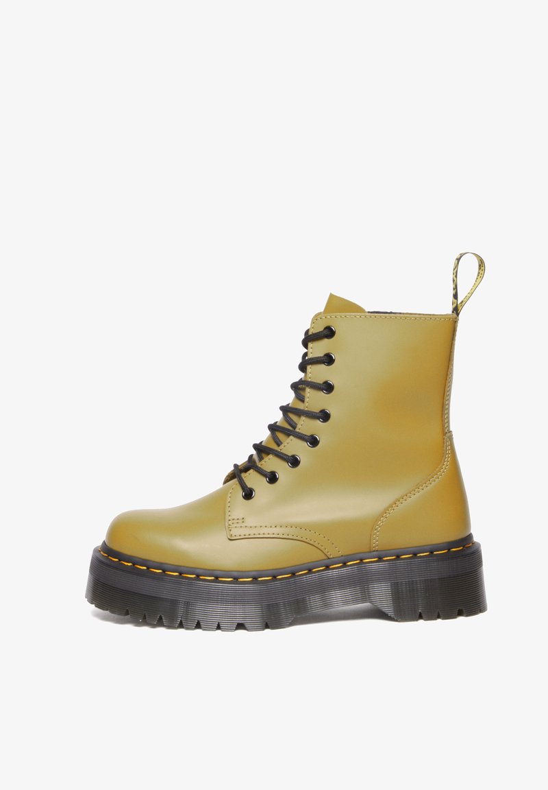 Bottes en caoutchouc jaunes à la cheville avec des lacets noirs, une semelle épaisse noire et des coutures oranges. Comprend une languette pour un enfilage facile.