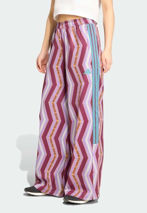 Pantalon à motif zigzag coloré dans des nuances de violet, bleu et or ; avec une taille élastique et des rayures sur les côtés. Fabriqué en matériel léger.