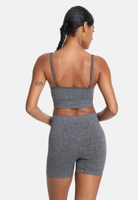 Sivý športový crop top s tenkými ramienkami a zodpovedajúcimi vysokými šortkami, s textúrovaným materiálom a priliehavým strihom.