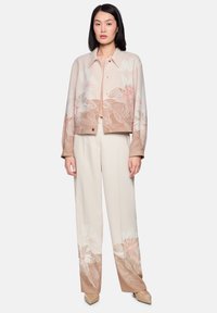 Light pink floral jacket with long sleeves, paired with cream-colored wide-leg trousers featuring similar floral patterns at the hem.