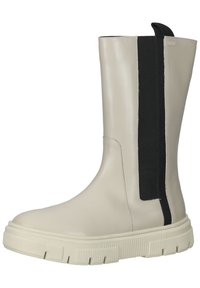 Bottine en cuir beige avec une épaisse semelle en caoutchouc blanche, dotée d'un grand panneau élastique noir sur le côté pour un enfilage facile.