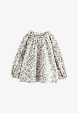 Blusa de manga larga beige claro con estampado floral negro. Presenta un escote elasticado y mangas abullonadas, creando un efecto de fruncido.