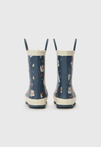 Bottes de pluie en caoutchouc bleu avec doublure en fourrure blanche, ornées d'un motif d'animaux fantaisiste, et d'un bord et de semelles couleur crème. Poignées pour un enfilage facile.