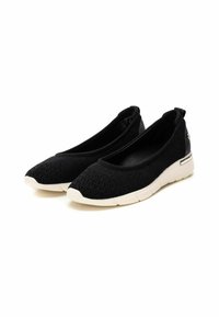 Zapatos negros tipo slip-on con parte superior de punto transpirable, punta redondeada, suela de goma blanca y un tirador en la parte trasera para facilitar su uso.
