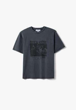 T-shirt a maniche corte grigio scuro con stampa vintage sbiadita nera di una band e i testi "SILENT CHAOS" e "NO RULES" sulla parte anteriore.