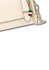 Cremfarbener Handtaschen-Eck mit goldenem Kettenriemen, goldener Verschluss und einem Schlüsselanhänger mit einem kleinen italienischen Flaggen-Anhänger.