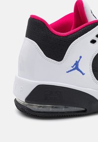 Biało-czarny but sportowy z błyszczącym wykończeniem, posiada różową siateczkową podszewkę, niebieskie logo oraz przezroczystą podeszwę powietrzną, fakturowaną gumową podeszwę zewnętrzną.