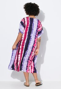 Mehrfarbiges Batik-Kleid mit lila, rosa und schwarzen Streifen, kurzen Ärmeln, lockerem Schnitt und weichem Stoff, der bis zur Mitte der Wade fällt.